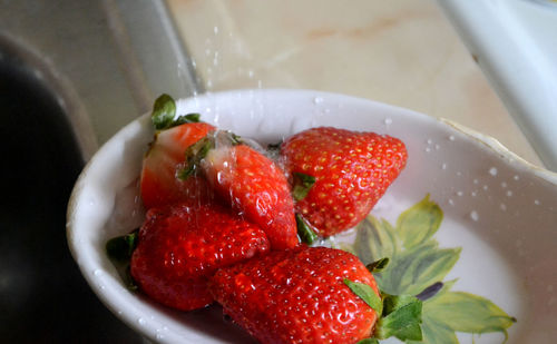 Close-up of strawberries being washed in container