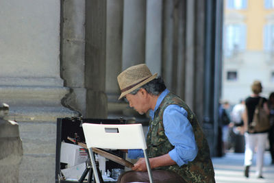 Side view of young woman holding smart phone