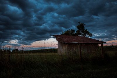 Scenic view of grassy field against cloudy sky