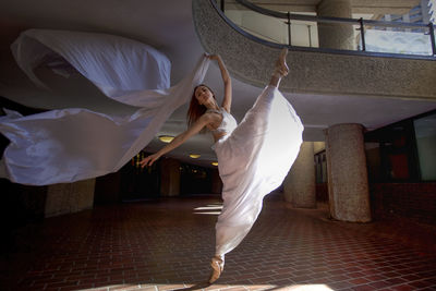 Midsection of woman dancing in corridor