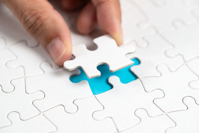 Cropped hand holding jigsaw piece
