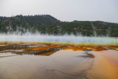 Steam emitting from geyser against clear sky