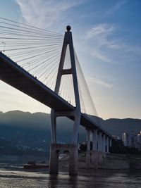 Low angle view of suspension bridge over river