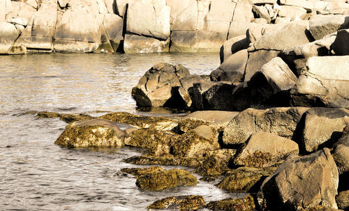 Rocks in sea by cave