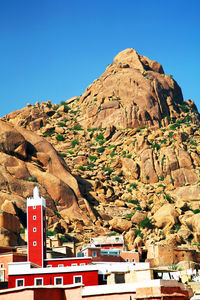 Houses by mountain against clear sky