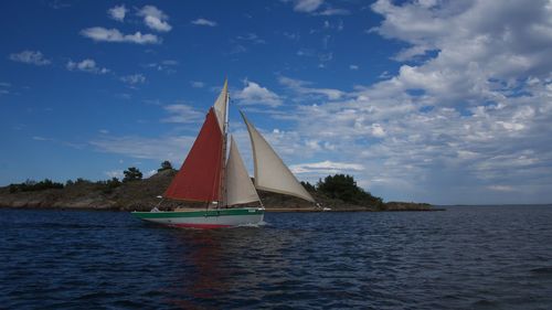 Sailboat sailing on sea against sky