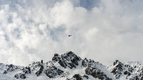 Low angle view of snowcapped mountains against sky