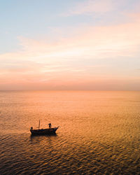 Silhouette boat in sea against sky during sunset