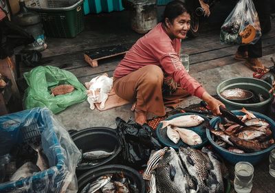 High angle view of woman sitting at fish market 