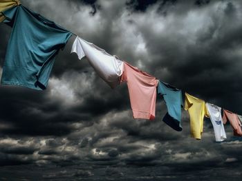 Low angle view of flags against cloudy sky