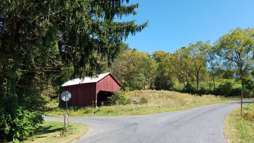 Road by house against clear sky