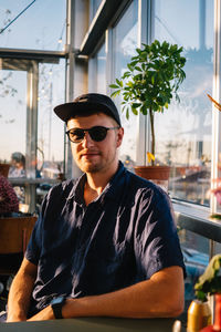 Portrait of young man wearing sunglasses at restaurant