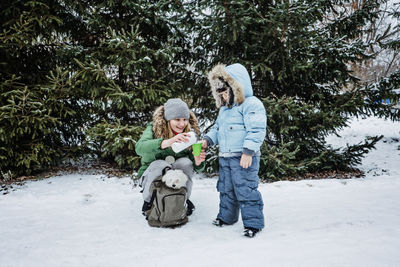 Outdoors winter activities for family. happy family, mother, boy kid and dog walking, having fun
