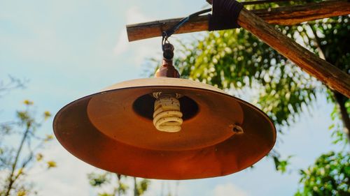 Low angle view of birdhouse hanging against sky