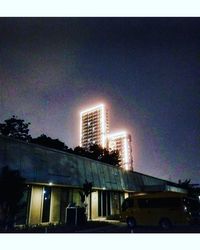 Low angle view of buildings against sky at night