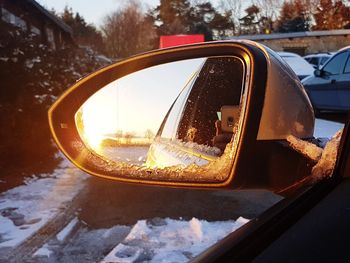 Close-up of snow on side-view mirror of car