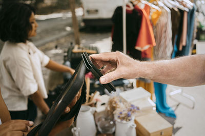 Hand of male customer paying via tap to pay while shopping at flea market