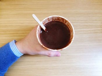 Close-up of hand holding drink on table