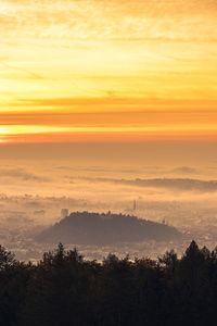 Graz city covered if fog on autumn morning during sunraise. view from plaubutsch 