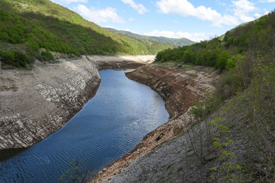 Scenic view of river amidst mountains against sky