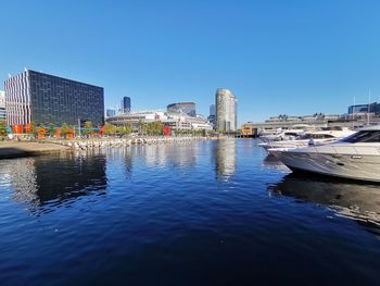 Buildings by city against clear blue sky