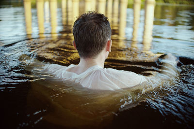 Rear view of man swimming in lake