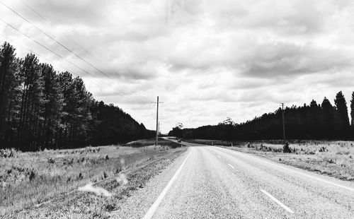 Road amidst field against sky