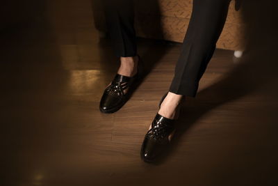 Low section of woman standing on hardwood floor