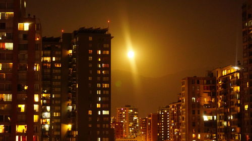 Illuminated cityscape against sky at night