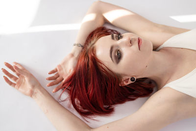 Woman model with fresh daily makeup and short red hair in studio.