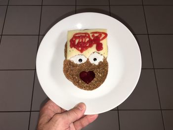 Cropped hand of man holding food in plate