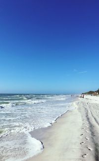 Scenic view of beach and sea against blue sky