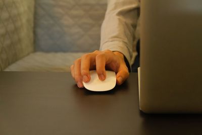 Midsection of man using laptop on table