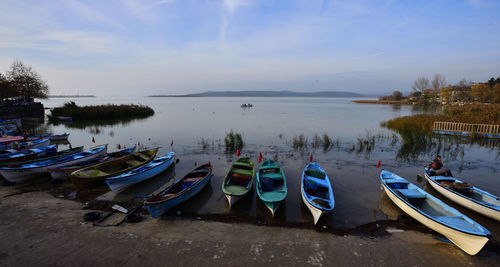 Panoramic view of boats moored in lake against sky