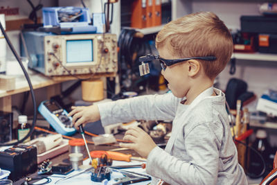 Side view of boy working on table