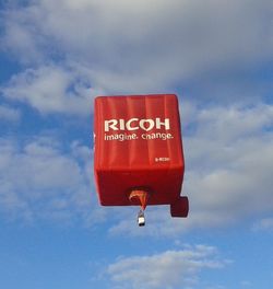 Low angle view of sign board against cloudy sky