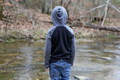 Rear view of boy standing by river