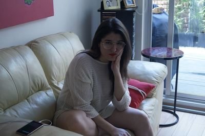 Young woman sitting on sofa at home