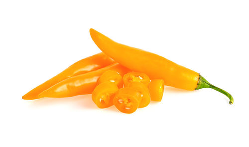 Close-up of orange chili pepper against white background