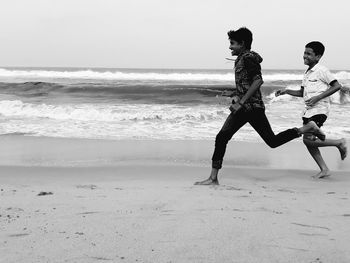 Full length of child on beach against sky