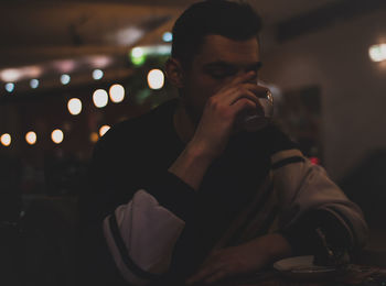 Close-up of young man drinking coffee at cafe