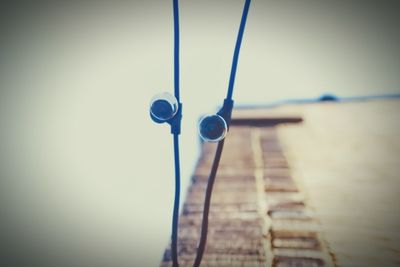 Close-up of rope hanging on pier against sky