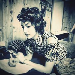 Young woman looking away while sitting at home