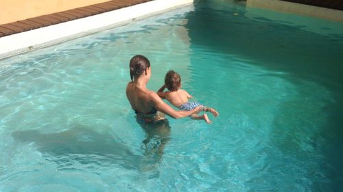 High angle view of mother with son in swimming pool