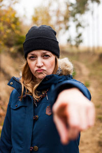 Portrait of young woman standing in park during winter