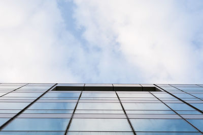 Low angle view of glass building against sky