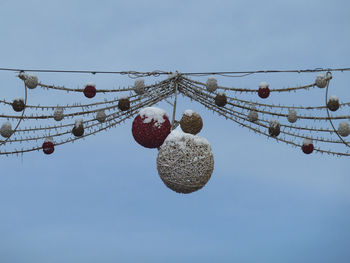 Low angle view of christmas decorations covered with snow against sky