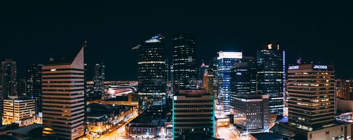 Illuminated buildings in city against sky at night