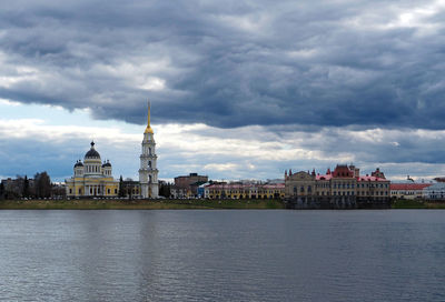 View of buildings in city against cloudy sky