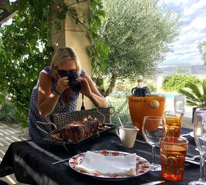 Midsection of woman holding drink sitting on table